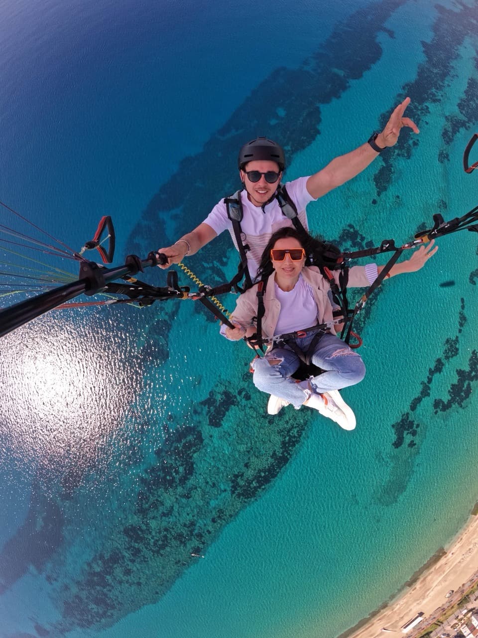 Tandem paragliding selfie above the turquoise water of Alanya